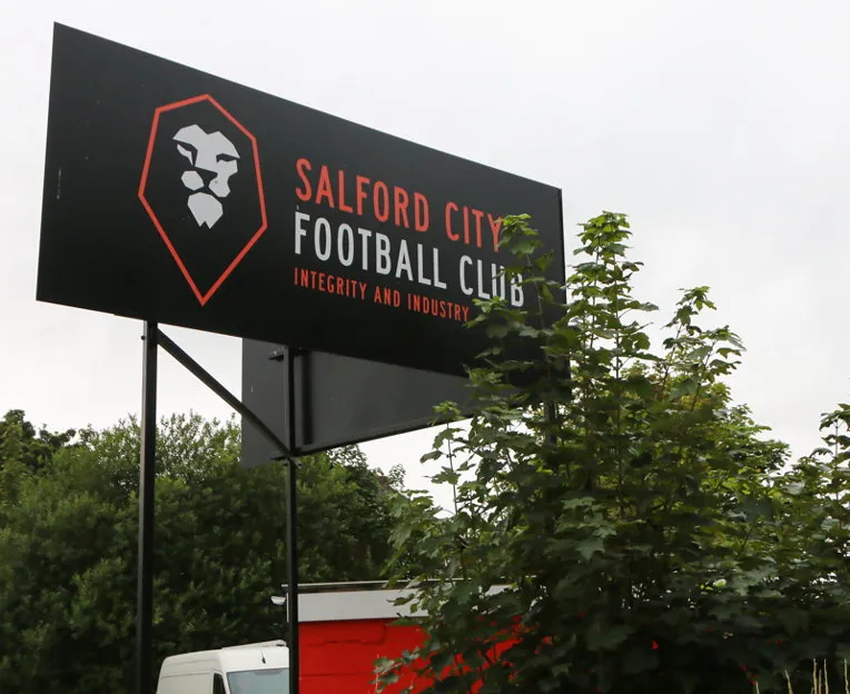 Biển hiệu màu đỏ nổi bật của Salford City FC bên ngoài sân vận động