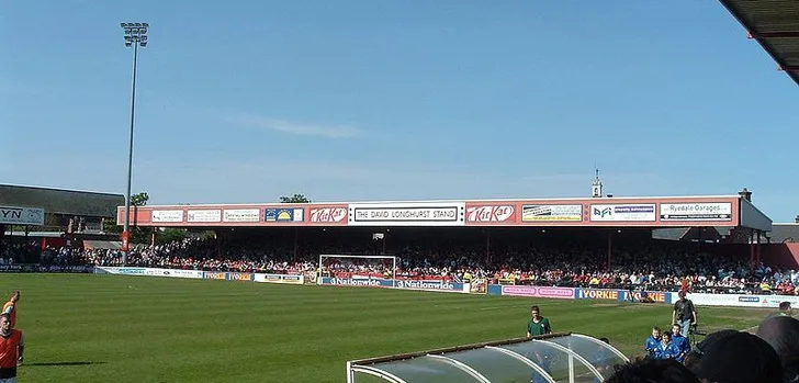 Góc nhìn từ khu vực huấn luyện viên ra sân cỏ và khán đài tại Bootham Crescent