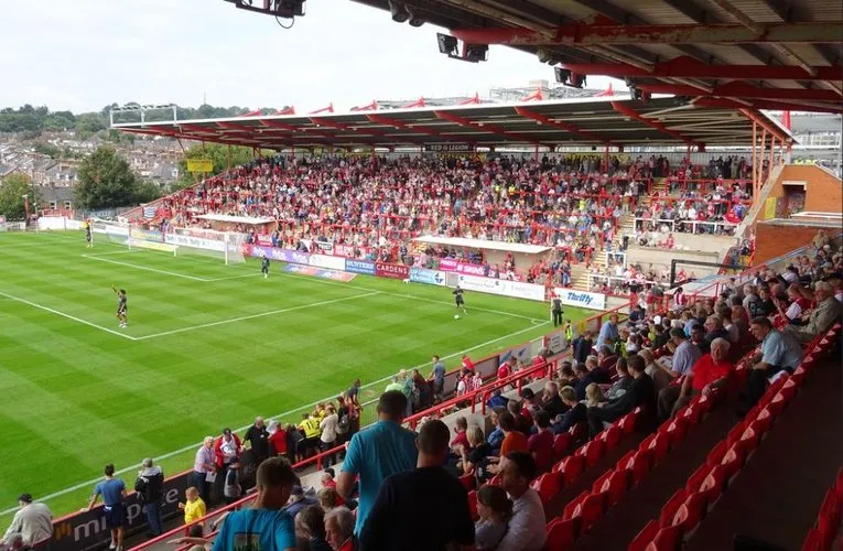 Không khí sôi động trên khán đài St. James Park vào ngày thi đấu, với các cổ động viên Exeter City hò reo.
