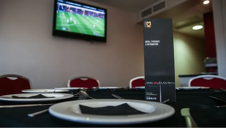 Khu vực hospitality tại Stadium MK, với bàn ăn và tầm nhìn ra sân