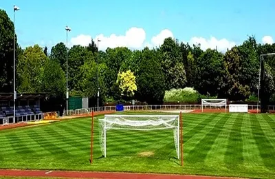 Toàn cảnh sân vận động Hornchurch nhìn từ khán đài, với đường chạy điền kinh bao quanh sân cỏ xanh mướt, biểu tượng của bóng đá cấp thấp Anh.