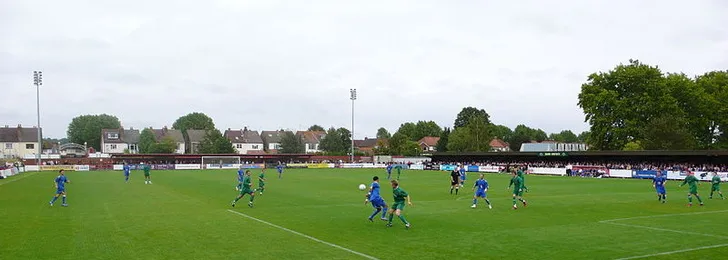 Trận đấu giữa AFC Wimbledon và Ramsgate tại Kingsmeadow, tái hiện một phần lịch sử sôi động của sân.